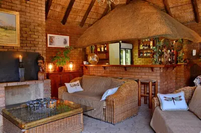 a living room with a couch and a fireplace at Owls Loft Guest House in Midrand