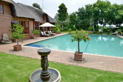 a swimming pool in front of a house at Owls Loft Guest House in Midrand