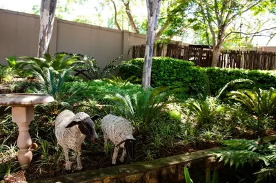 two statues of sheep standing in a garden at 37 on Charles in Pretoria