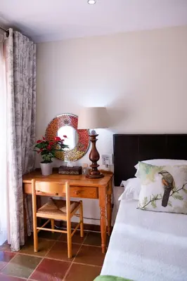 a bedroom with a bed and a table with a lamp at 37 on Charles in Pretoria