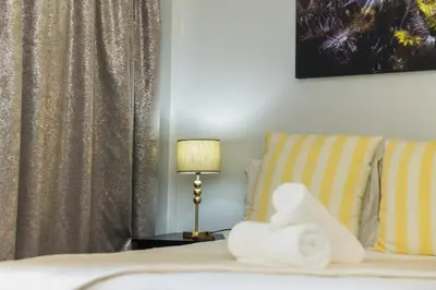 a hotel room with a bed and a lamp and towels at Rozendal Guest House in Centurion