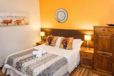 a bedroom with a bed and two lamps at Rozendal Guest House in Centurion