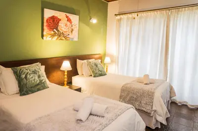 a hotel room with two beds and a window at Rozendal Guest House in Centurion