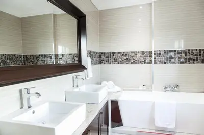 a white bathroom with two sinks and a mirror at Victorian Guest House in Nelspruit