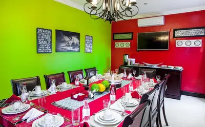 a dining room with a long table with red and green walls at Victorian Guest House in Nelspruit