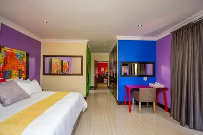 a bedroom with a large bed and a red table at Victorian Guest House in Nelspruit