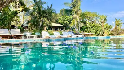 a swimming pool with lounge chairs in a resort at LoerieRoep Estate - Mountainview Selfcatering Accommodation Nelspruit in Nelspruit
