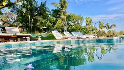 a swimming pool with lounge chairs next to the water at LoerieRoep Estate - Mountainview Selfcatering Accommodation Nelspruit in Nelspruit