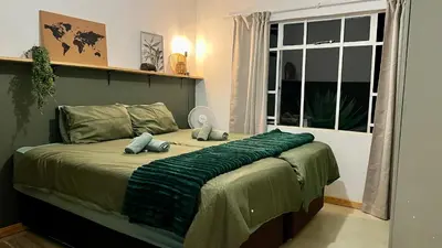 a bedroom with a bed with two pillows on it at LoerieRoep Estate - Mountainview Selfcatering Accommodation Nelspruit in Nelspruit