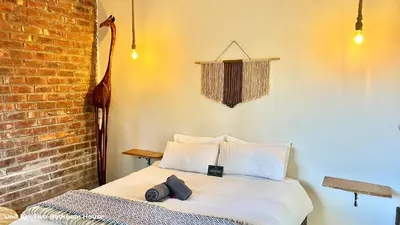 a bed in a room with a brick wall at LoerieRoep Estate - Mountainview Selfcatering Accommodation Nelspruit in Nelspruit