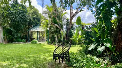 a chair sitting in a yard with a gazebo at LoerieRoep Estate - Mountainview Selfcatering Accommodation Nelspruit in Nelspruit
