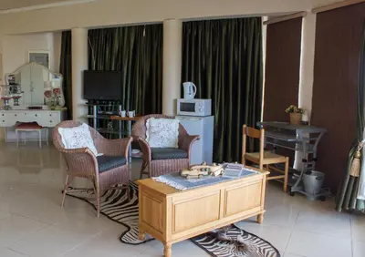 a living room with chairs and a coffee table at Villa-Candilabra Guesthouse in Komatipoort