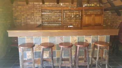 a bar with four stools in a room at Albatross B&B in Benoni
