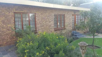 a brick house with windows and a garden at Albatross B&B in Benoni
