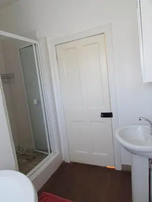 a bathroom with a white door and a sink at Absolute Leisure Cottages in Machadodorp