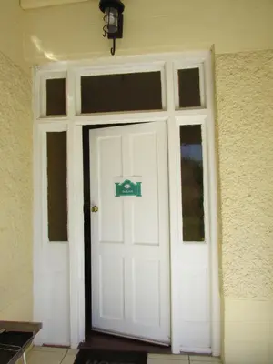 a white door with a sign on it at Absolute Leisure Cottages in Machadodorp