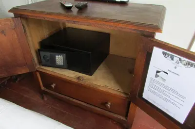a microwave in a wooden cabinet with a sign at Absolute Leisure Cottages in Machadodorp