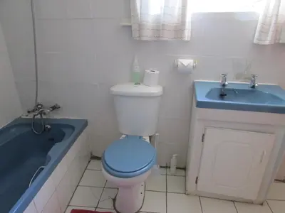 a bathroom with a toilet and a sink and a tub at Absolute Leisure Cottages in Machadodorp