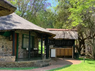 a house with a thatch roof and a patio at Lepêllê Lodge in Burgersfort