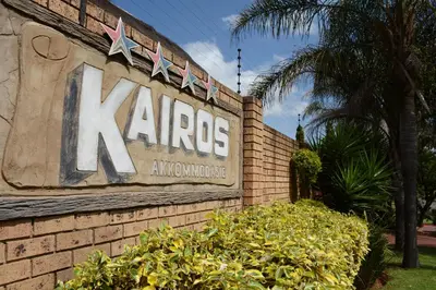 a sign on a brick wall with a k arros sign at Kairos Home in Middelburg