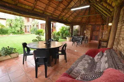 a patio with a table and a couch and a table and chairs at Kairos Home in Middelburg