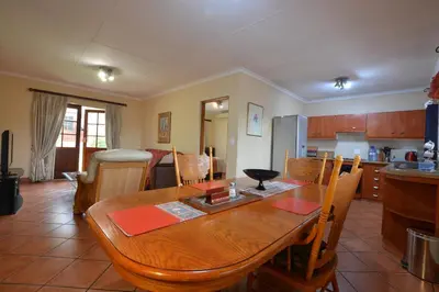a kitchen and dining room with a wooden table at Kairos Home in Middelburg