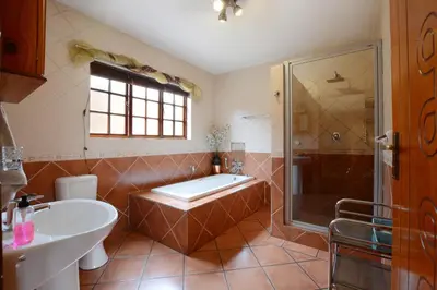 a bathroom with a tub and a shower and a sink at Kairos Home in Middelburg