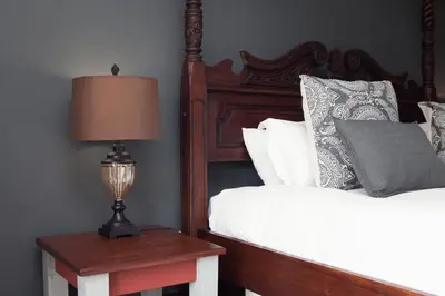 a bedroom with a bed and a table with a lamp at Annie's Boutique Guesthouse and Garden Spa in Hartbeespoort