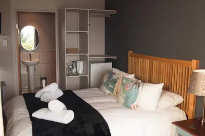 a bedroom with two beds with towels on them at Annie's Boutique Guesthouse and Garden Spa in Hartbeespoort