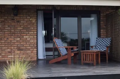 two chairs and a table on a porch at Annie's Boutique Guesthouse and Garden Spa in Hartbeespoort