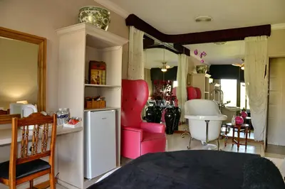 a living room with pink chairs and a sink at Annie's Boutique Guesthouse and Garden Spa in Hartbeespoort