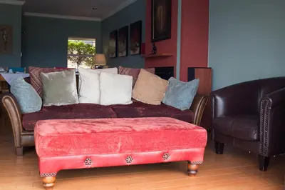 a living room with a red couch and two chairs at Annie's Boutique Guesthouse and Garden Spa in Hartbeespoort