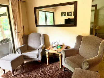 a living room with two chairs and a coffee table at Silver Mist Resort, Haenertsburg in Haenertsburg