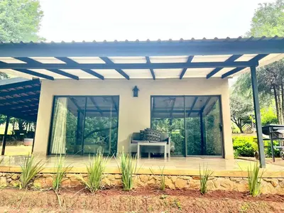 a pavilion with a table in front of a house at Silver Mist Resort, Haenertsburg in Haenertsburg