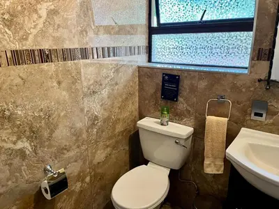 a bathroom with a toilet and a sink and a window at Silver Mist Resort, Haenertsburg in Haenertsburg
