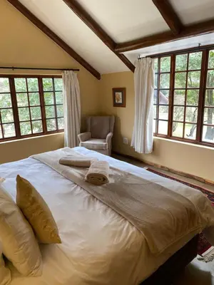 a large bed in a bedroom with windows at Waterberg Cottages, Private Game Reserve in Vaalwater
