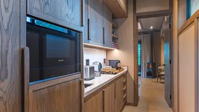a kitchen with wooden cabinets and a large television at Elephant Point in Skukuza