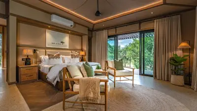 a bedroom with a large bed and a table and chairs at Elephant Point in Skukuza