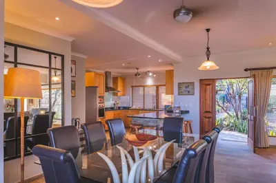 a dining room and kitchen with a table and chairs at Elephant Point in Skukuza