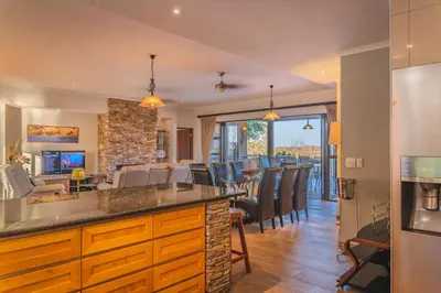 a kitchen and living room with a bar and chairs at Elephant Point in Skukuza