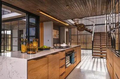 a large kitchen with wooden cabinets and a staircase at Elephant Point in Skukuza