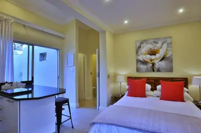 a bedroom with a large bed with red pillows at Andante Lodge in Pretoria