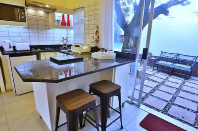 a kitchen with a counter and two stools at Andante Lodge in Pretoria