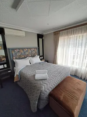 a bedroom with a large bed with two towels on it at Constantia Manor Guest House in Pretoria