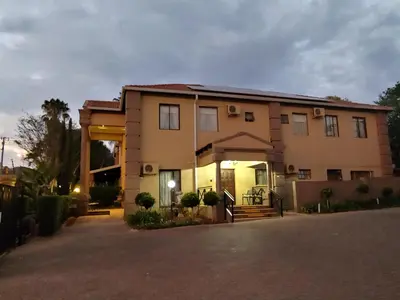a large house with a driveway in front of it at Constantia Manor Guest House in Pretoria