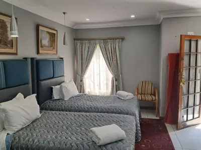 a bedroom with a bed and a window at Constantia Manor Guest House in Pretoria