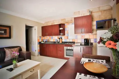 a kitchen with wooden cabinets and a table in a room at Accommodation at Vans No Loadshedding in Centurion