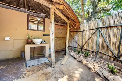 a barn with a wooden fence and a table at Umlani Bushcamp in Timbavati Game Reserve