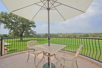 a table and chairs with an umbrella on a balcony at Leopardsong Manor in Centurion