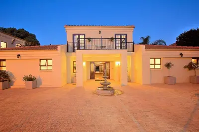 a large white house with a balcony on top of it at Leopardsong Manor in Centurion